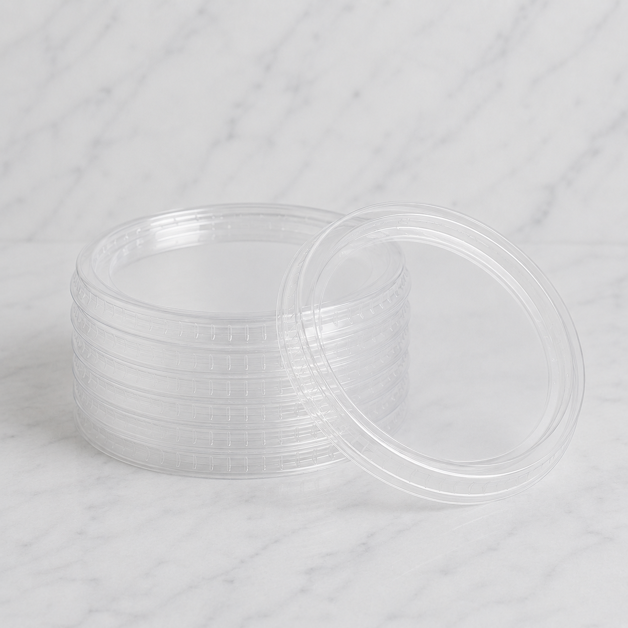 Stack of clear plastic containers with lids on a white background