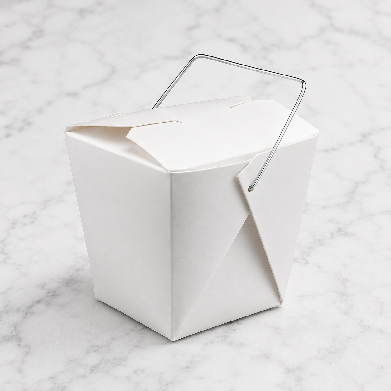 White paper lunch box with a metal handle on a marble surface